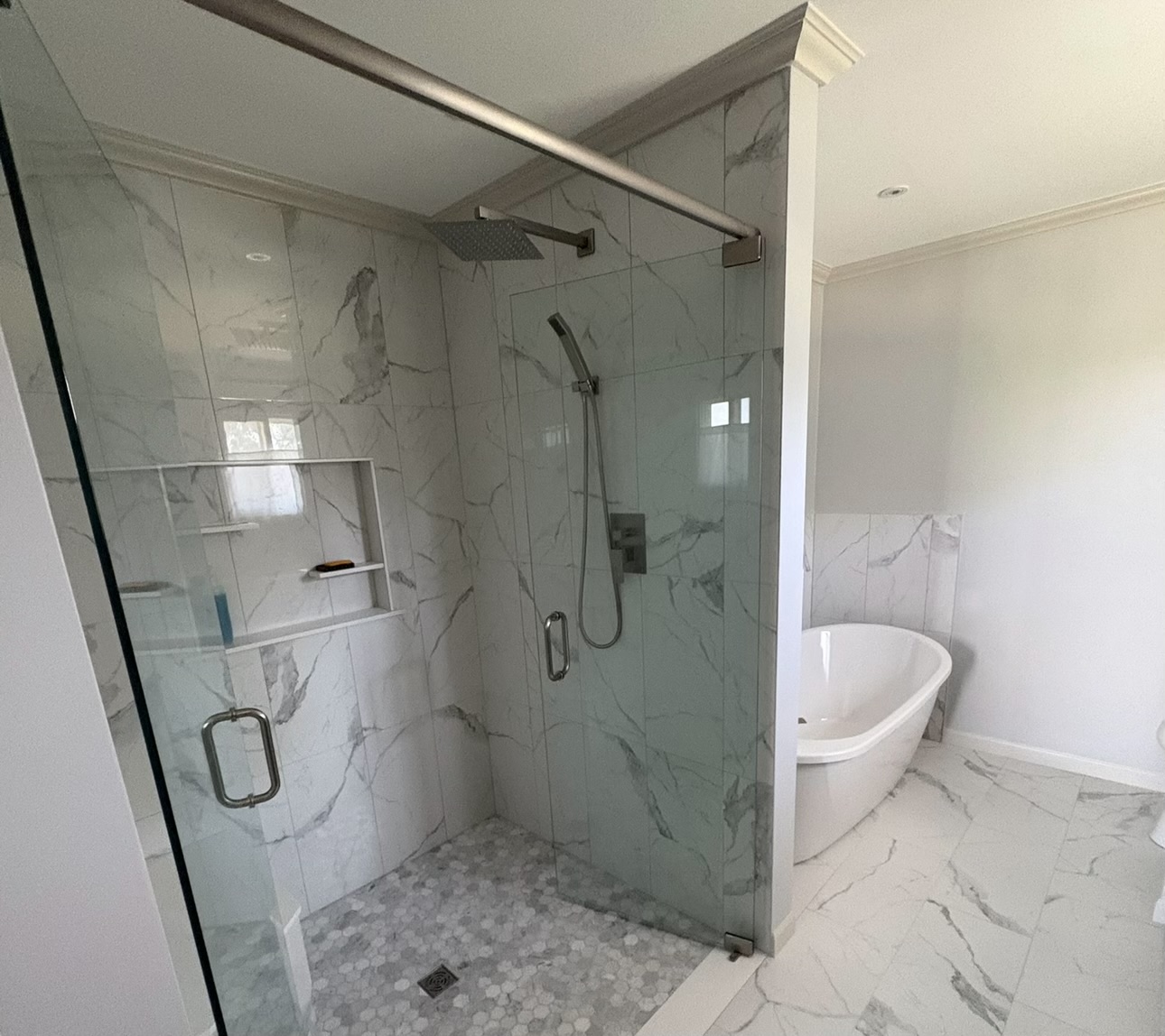 Monroe, MI bathroom remodel with marble look tile and custom glass shower.